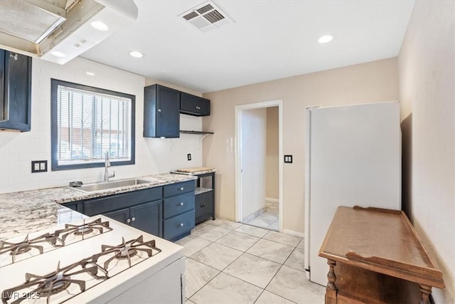 3715 Tabor Ave, North Las Vegas, NV 89030 - kitchen with white appliances, recessed lighting, blue cabinetry, and backsplash