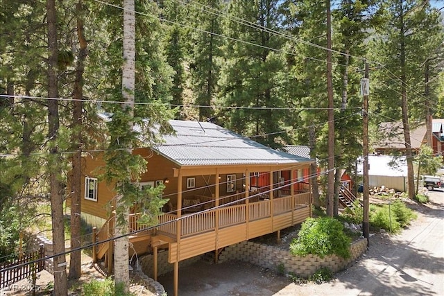 4581 Aspen Ave, Mount Charleston, NV 89124 - rear view of house with stairs, a wooden deck, a view of trees, and a metal roof