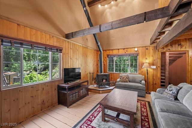 4581 Aspen Ave, Mount Charleston, NV 89124 - living room featuring a wood stove, wooden walls, beam ceiling, light wood-style flooring, and high vaulted ceiling