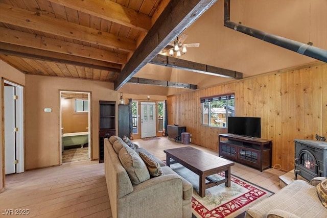4581 Aspen Ave, Mount Charleston, NV 89124 - living room with a wood stove, light wood-type flooring, a wooden ceiling with exposed beams, wooden walls, and ceiling fan