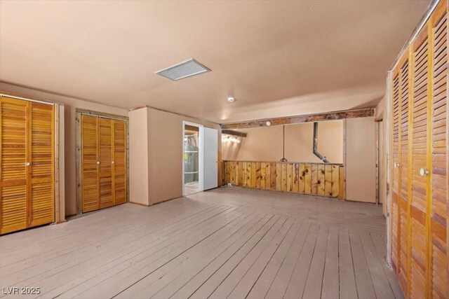 4581 Aspen Ave, Mount Charleston, NV 89124 - unfurnished bedroom with wood-type flooring, two closets, and wood walls
