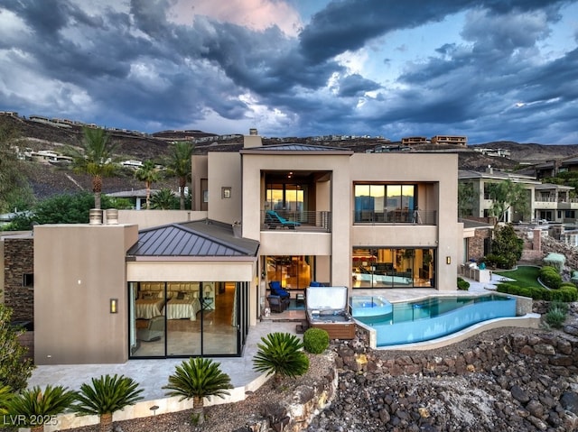 583 Saint Croix St, Henderson, NV 89012 - back of house with a balcony, a standing seam roof, stucco siding, a patio, and a metal roof