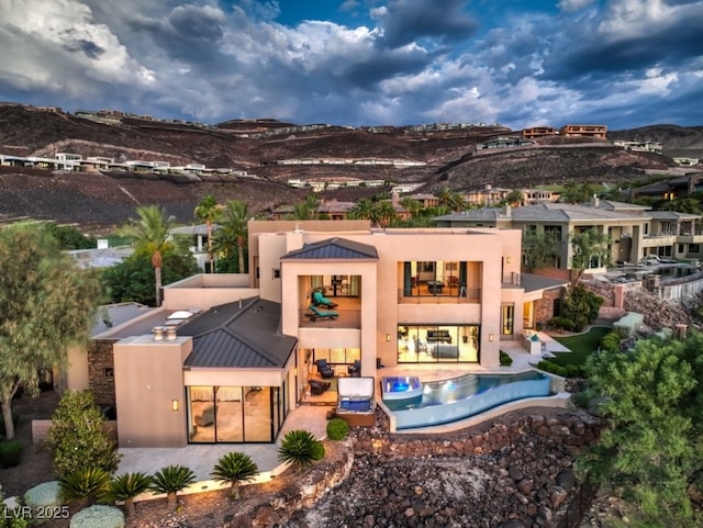 583 Saint Croix St, Henderson, NV 89012 - rear view of property featuring a balcony, stucco siding, a patio, a mountain view, and a standing seam roof