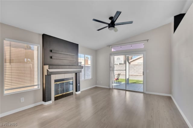 2229 Bowstring Dr, Las Vegas, NV 89142 - unfurnished living room featuring wood finished floors, a tile fireplace, ceiling fan, and vaulted ceiling