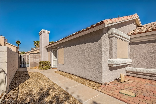 2229 Bowstring Dr, Las Vegas, NV 89142 - view of side of property with a gate, stucco siding, and a tile roof