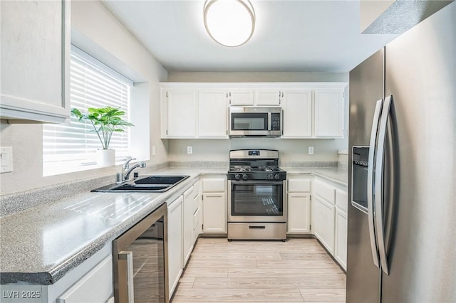 2229 Bowstring Dr, Las Vegas, NV 89142 - kitchen with appliances with stainless steel finishes, beverage cooler, white cabinetry, light wood finished floors, and light countertops