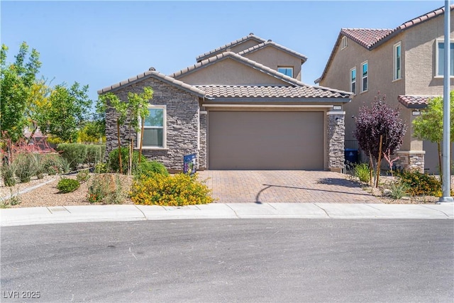 4376 Latitude Valley Ct, North Las Vegas, NV 89084 - mediterranean / spanish-style house with stone siding, a tile roof, an attached garage, decorative driveway, and stucco siding