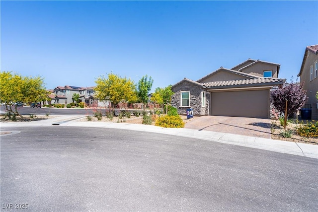 4376 Latitude Valley Ct, North Las Vegas, NV 89084 - view of front of home featuring stone siding, an attached garage, driveway, a tile roof, and a residential view