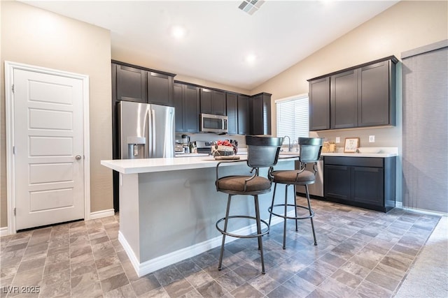 4376 Latitude Valley Ct, North Las Vegas, NV 89084 - kitchen featuring stainless steel appliances, lofted ceiling, stone finish flooring, a breakfast bar, and light countertops