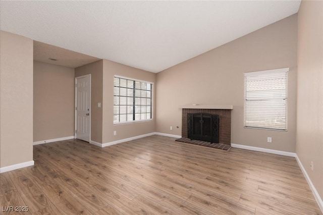 317 Brent Ct, Henderson, NV 89074 - unfurnished living room featuring wood finished floors, a fireplace, and vaulted ceiling