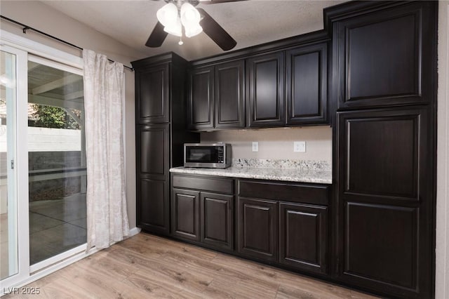 317 Brent Ct, Henderson, NV 89074 - kitchen with stainless steel microwave, a ceiling fan, and light wood-style floors