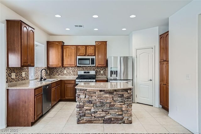 10428 Mulvaney Cir, Las Vegas, NV 89141 - kitchen featuring stainless steel appliances, tasteful backsplash, light tile patterned flooring, light stone countertops, and a center island