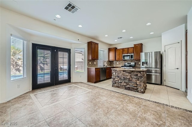 10428 Mulvaney Cir, Las Vegas, NV 89141 - kitchen with appliances with stainless steel finishes, french doors, tasteful backsplash, light tile patterned floors, and recessed lighting