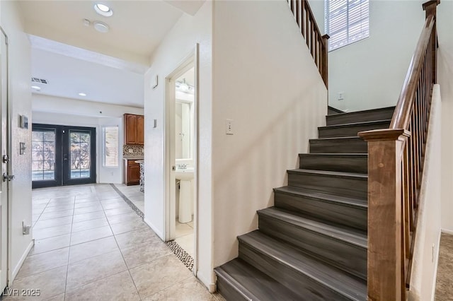 10428 Mulvaney Cir, Las Vegas, NV 89141 - stairway with healthy amount of natural light, tile patterned floors, recessed lighting, and french doors