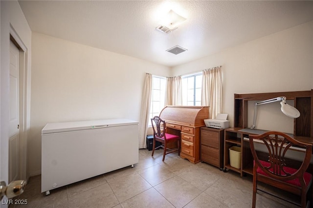 4616 E Idaho Ave, Las Vegas, NV 89104 - bedroom featuring a desk, light tile patterned floors, fridge, and a textured ceiling