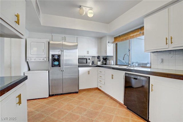 205 E Harmon Ave Unit 306, Las Vegas, NV 89169 - kitchen with appliances with stainless steel finishes, stacked washer / drying machine, dark countertops, and white cabinetry