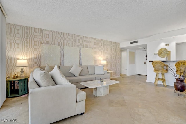 205 E Harmon Ave Unit 306, Las Vegas, NV 89169 - living room featuring wallpapered walls, a textured ceiling, and an accent wall