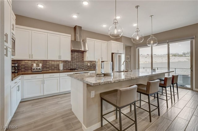4336 Guava Ct Unit 0, Las Vegas, NV 89135 - kitchen featuring wall chimney exhaust hood, appliances with stainless steel finishes, decorative backsplash, white cabinets, and recessed lighting