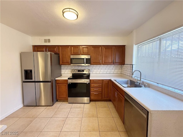3270 Liahona Way, Las Vegas, NV 89121 - kitchen featuring appliances with stainless steel finishes, light countertops, decorative backsplash, and brown cabinetry
