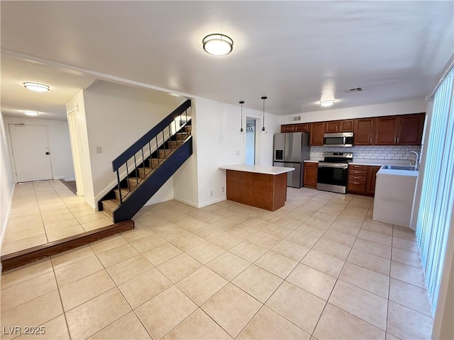 3270 Liahona Way, Las Vegas, NV 89121 - kitchen featuring appliances with stainless steel finishes, light countertops, light tile patterned floors, backsplash, and a peninsula
