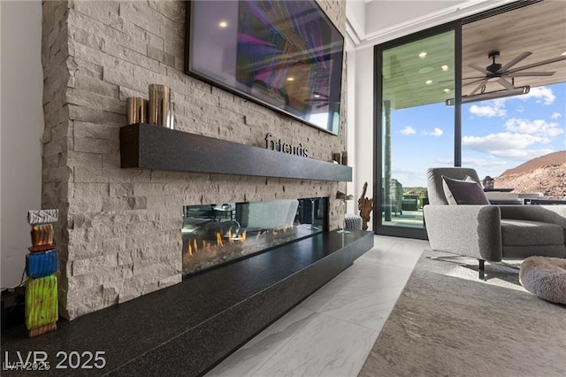 387 Solitude Peak Ln, Henderson, NV 89012 - living room featuring a multi sided fireplace, ceiling fan, floor to ceiling windows, marble finish floors, and plenty of natural light