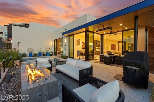 387 Solitude Peak Ln, Henderson, NV 89012 - patio terrace at dusk with an outdoor living space with a fire pit, a patio area, and a grill