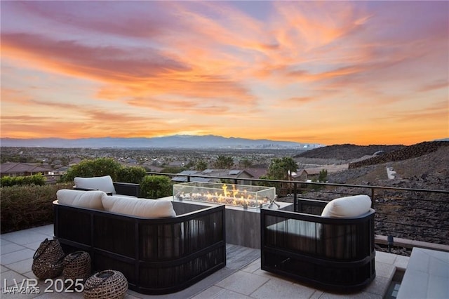387 Solitude Peak Ln, Henderson, NV 89012 - patio terrace at dusk featuring an outdoor living space with a fire pit and a mountain view