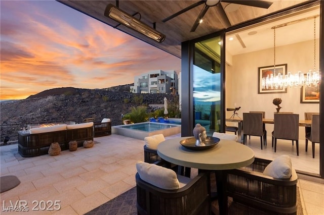 387 Solitude Peak Ln, Henderson, NV 89012 - view of patio featuring a ceiling fan, outdoor dining space, a jacuzzi, and a mountain view