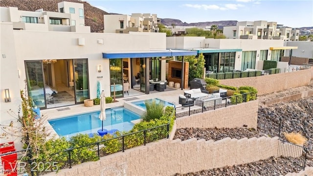 387 Solitude Peak Ln, Henderson, NV 89012 - rear view of property featuring a patio area, stucco siding, a pool with connected hot tub, and a residential view
