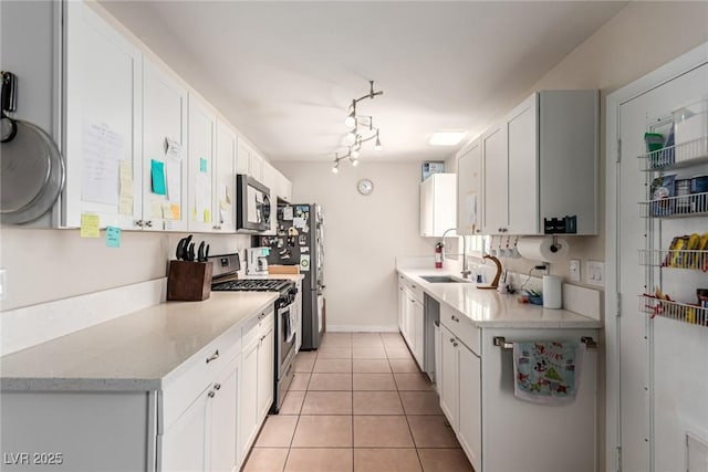 4168 Wendy Ln, Las Vegas, NV 89115 - kitchen with stainless steel appliances, white cabinets, light tile patterned floors, and light stone countertops