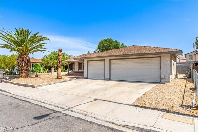 4168 Wendy Ln, Las Vegas, NV 89115 - ranch-style house with stucco siding, an attached garage, and concrete driveway