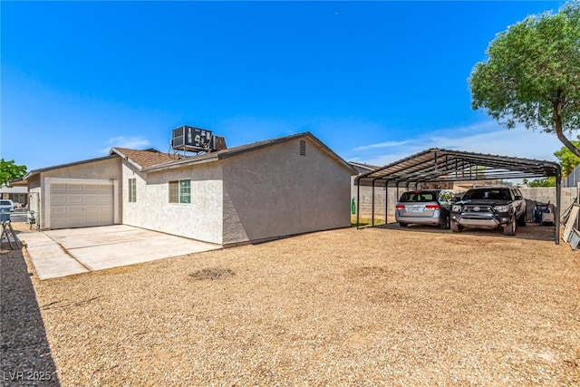 4168 Wendy Ln, Las Vegas, NV 89115 - view of side of home with stucco siding, concrete driveway, a garage, and a detached carport
