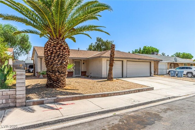 4168 Wendy Ln, Las Vegas, NV 89115 - view of front of house with an attached garage, driveway, and stucco siding