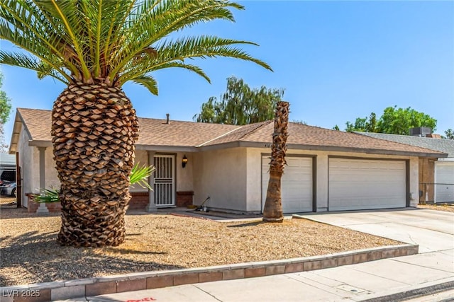 4168 Wendy Ln, Las Vegas, NV 89115 - ranch-style home with stucco siding, a garage, concrete driveway, and roof with shingles