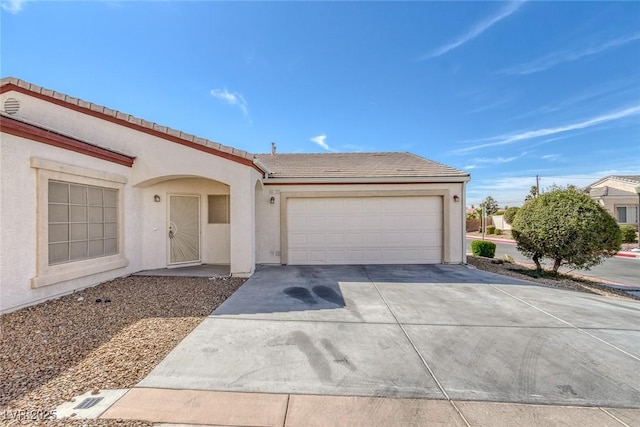 4828 Marco Polo St, North Las Vegas, NV 89031 - view of front facade featuring driveway, stucco siding, a tile roof, and an attached garage