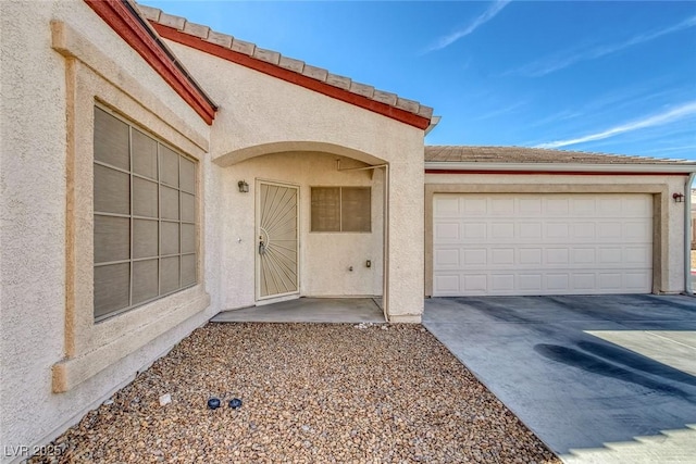 4828 Marco Polo St, North Las Vegas, NV 89031 - view of exterior entry featuring concrete driveway, an attached garage, and stucco siding
