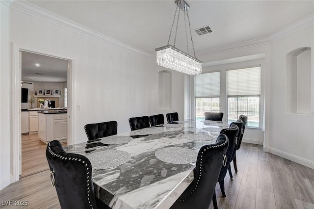 2496 Ram Crossing Way, Henderson, NV 89074 - dining area with ornamental molding, light wood-style flooring, and a chandelier