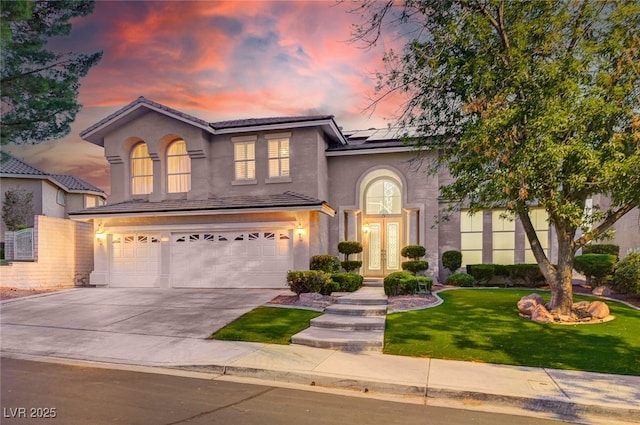 2496 Ram Crossing Way, Henderson, NV 89074 - traditional home featuring french doors, a garage, a front yard, roof mounted solar panels, and stucco siding
