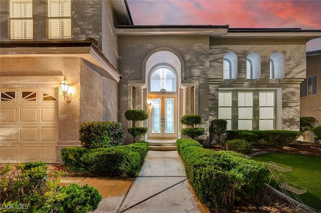 2496 Ram Crossing Way, Henderson, NV 89074 - exterior entry at dusk featuring french doors and an attached garage