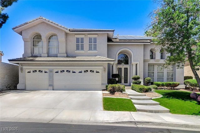 2496 Ram Crossing Way, Henderson, NV 89074 - mediterranean / spanish-style house featuring french doors, solar panels, an attached garage, concrete driveway, and stucco siding