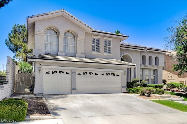 2496 Ram Crossing Way, Henderson, NV 89074 - view of front of property featuring a garage, stucco siding, roof mounted solar panels, concrete driveway, and a gate
