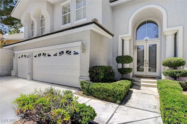 2496 Ram Crossing Way, Henderson, NV 89074 - doorway to property with french doors, stucco siding, a garage, and driveway