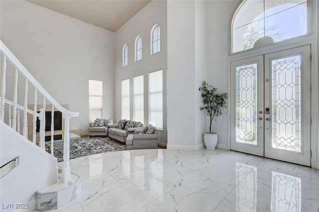 2496 Ram Crossing Way, Henderson, NV 89074 - foyer with marble tiled floors, french doors, plenty of natural light, stairs, and a high ceiling