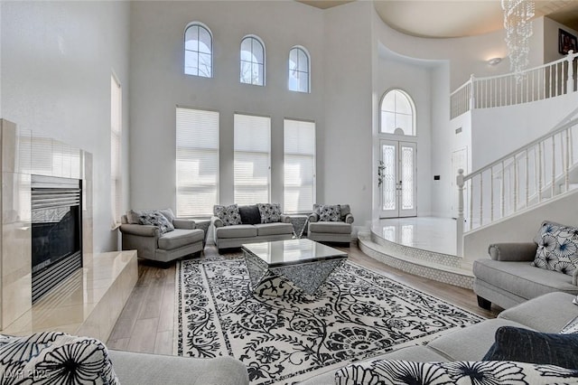 2496 Ram Crossing Way, Henderson, NV 89074 - living area featuring a towering ceiling, wood finished floors, stairway, and a fireplace