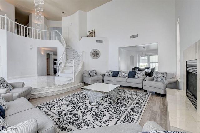 2496 Ram Crossing Way, Henderson, NV 89074 - living area featuring a high ceiling, stairway, wood finished floors, and a premium fireplace