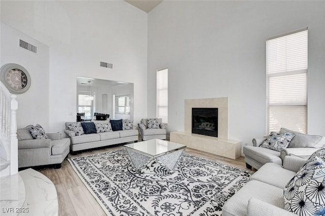 2496 Ram Crossing Way, Henderson, NV 89074 - living area with a high ceiling, light wood finished floors, and a tile fireplace