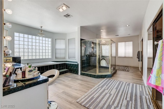 2496 Ram Crossing Way, Henderson, NV 89074 - bathroom featuring a shower stall, plenty of natural light, wood finished floors, recessed lighting, and a tub to relax in