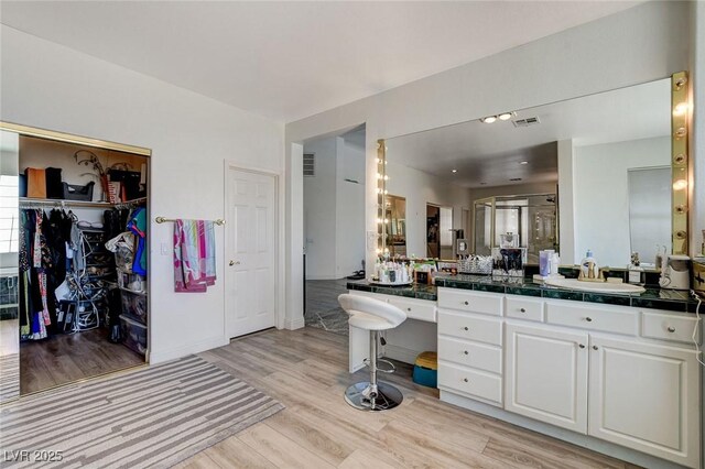 2496 Ram Crossing Way, Henderson, NV 89074 - bathroom featuring wood finished floors, vanity, and a walk in closet