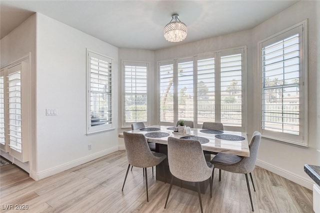 2496 Ram Crossing Way, Henderson, NV 89074 - dining area with light wood-style floors, healthy amount of natural light, and a chandelier