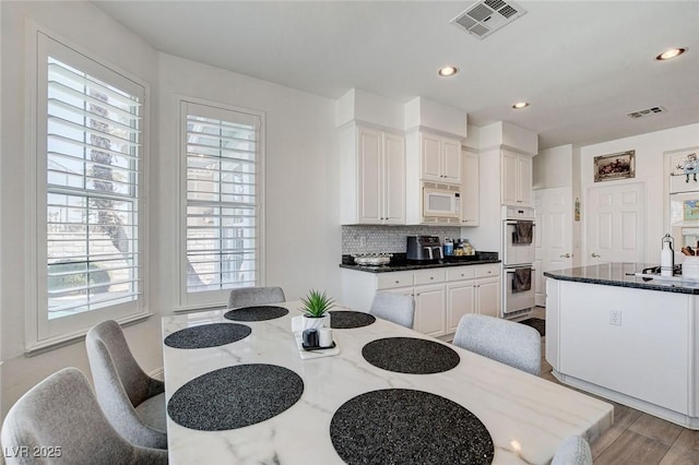 2496 Ram Crossing Way, Henderson, NV 89074 - kitchen featuring white appliances, backsplash, dark stone countertops, white cabinets, and recessed lighting